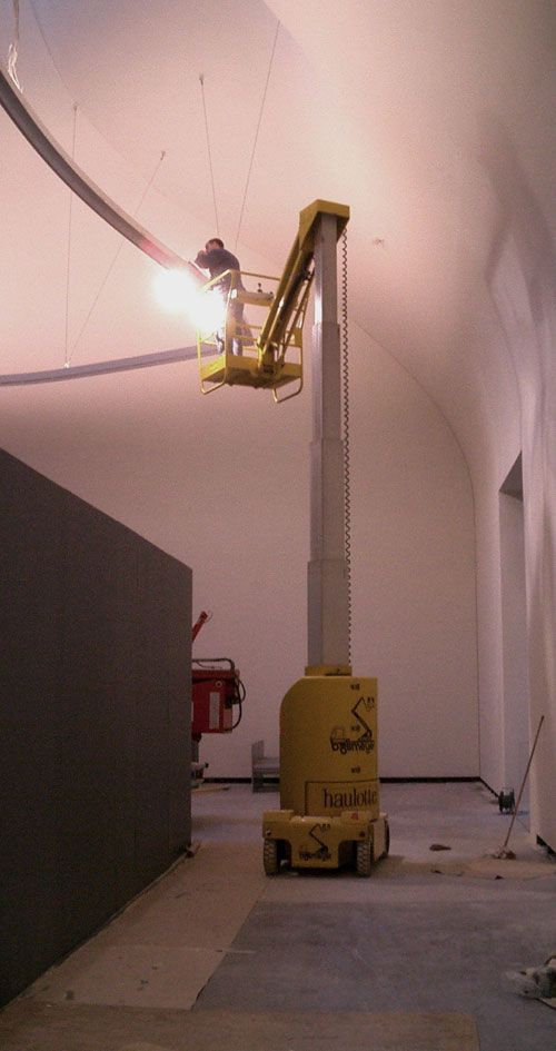 Ein Mann steht auf einer Hebebühne