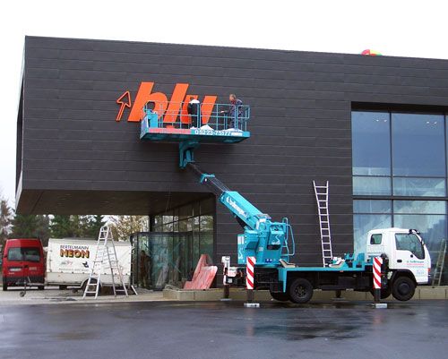 Eine Hebebühne wird verwendet um ein Schild anzubringen